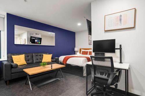 a room with a bed and a couch and a desk at CozySuites Stunning 1BR in Downtown Pitts #1 in Pittsburgh