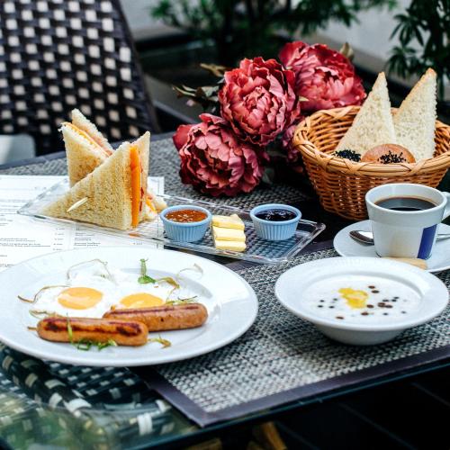 a table with a breakfast of eggs and bread at The Villa Hotel in Unawatuna