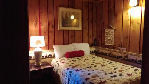 a bedroom with a bed in a wooden wall at Alpine Motel in Branch Township