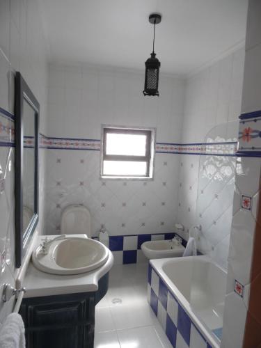 a bathroom with a sink and a tub and a toilet at Apartamento Bela Vista in Pereira