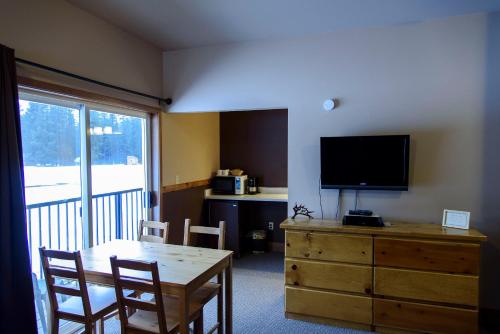 sala de estar con mesa y tocador con TV en Leavenworth Camping Resort Lakeview Lodge 2, en Leavenworth