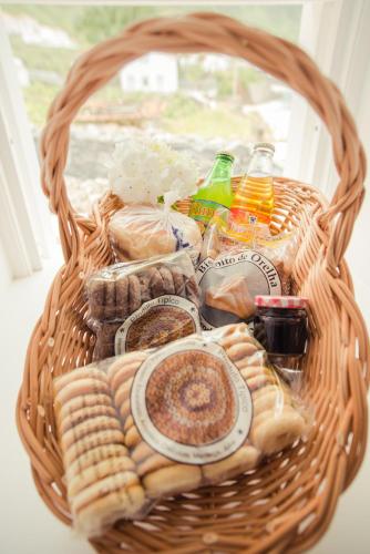 a basket filled with food and drinks and snacks at Vigia da Areia in São Lourenço