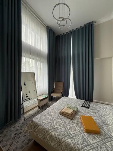 a bedroom with a bed with a mirror and a chair at Villa Caprice 42 Issyk Kul in Bosteri