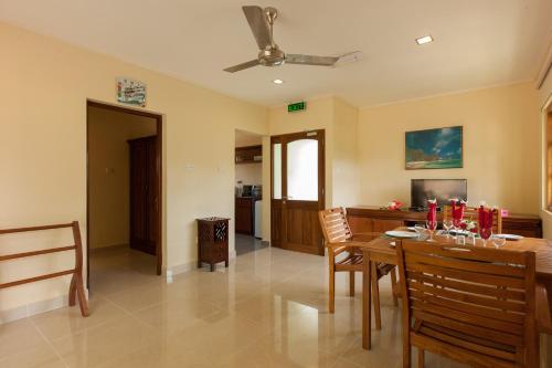 a living room with a dining room table and chairs at Le Relax Self Catering Apartment in La Digue