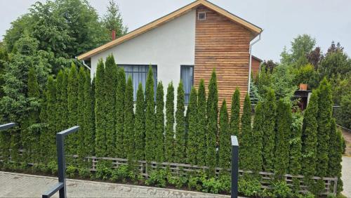 a house with a hedge in front of a fence at Villa Caprice 42 Issyk Kul in Bosteri
