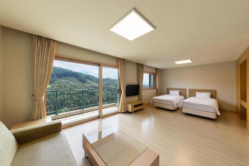a large room with two beds and a large window at OakValley Resort Hills Village in Wonju