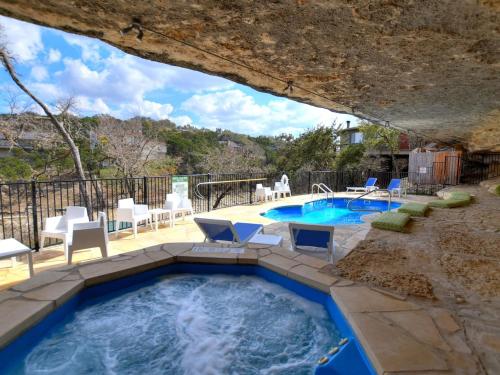 a pool in a backyard with chairs and a table at Lakefront Bungalow with Community PoolHot Tub #3 in Lakeway
