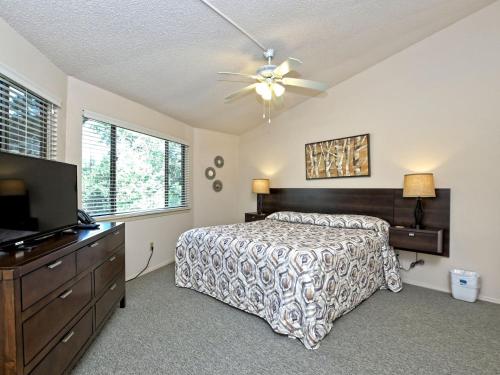 a bedroom with a bed and a ceiling fan at Lakefront Bungalow - Community Poolhot Tub #6 in Lakeway