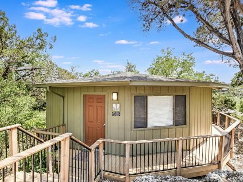 a green tiny house with a wooden deck at Lakefront Bungalow With Community Poolhot Tub #1 in Lakeway