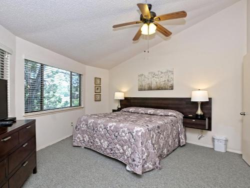 a bedroom with a bed and a ceiling fan at Treehouse Bungalow - Community Poolhot Tub #13 in Lakeway