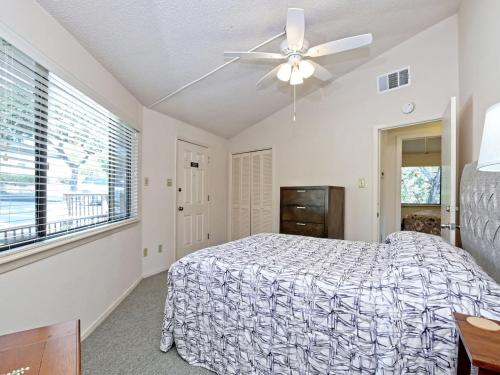 a bedroom with a bed and a ceiling fan at Treehouse Bungalow - Community Poolhot Tub #13 in Lakeway