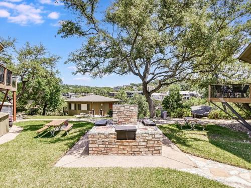 a backyard with a brick grill in the grass at Treehouse Bungalow - Community Poolhot Tub #13 in Lakeway