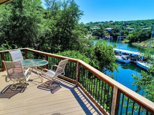 a balcony with a table and chairs and a view of a river at Lakefront Bungalow With Community Poolhot Tub #9 in Lakeway