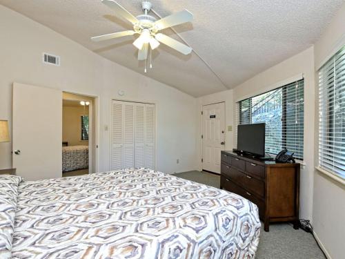 a bedroom with a bed and a ceiling fan at Lakefront Bungalow With Community Poolhot Tub #9 in Lakeway