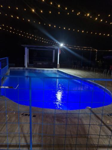 a swimming pool lit up at night with lights at Mirador la escondia in Neiva