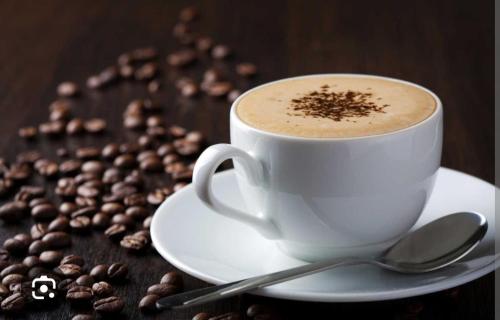 a cup of coffee on a plate with coffee beans at Mirador la escondia in Neiva