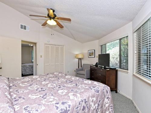 a bedroom with a bed and a ceiling fan at Lakefront Bungalow - Community Poolhot Tub #10 in Lakeway