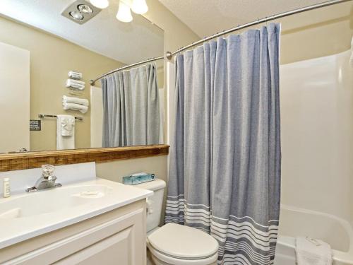 a bathroom with a sink and a toilet and a shower at Treehouse Bungalow - Community Poolhot Tub #17 in Lakeway