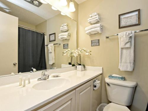 a bathroom with a sink and a toilet and a mirror at Treehouse Bungalow - Community Poolhot Tub #17 in Lakeway