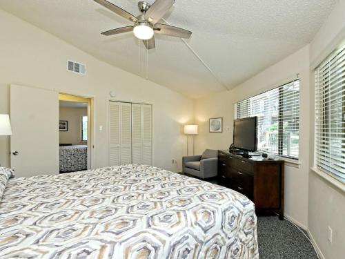 a bedroom with a bed and a ceiling fan at Treehouse Bungalow - Community Poolhot Tub #17 in Lakeway