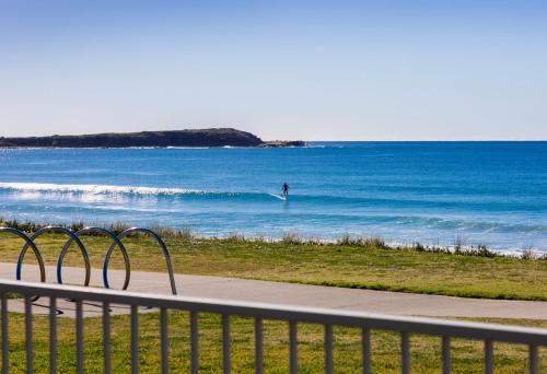 a person riding a wave in the ocean at Seabreeze on the Beach in Barrack Point
