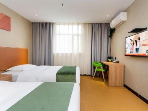 a hotel room with two beds and a television at Shell Hotel Shnaghai Beiqiao Metro Station in Shanghai