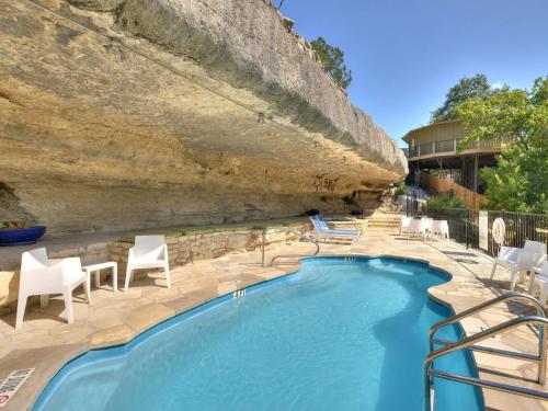 a swimming pool with chairs and a rock wall at Lake Travis Bungalow Casita Golden Rod #2 in Lakeway