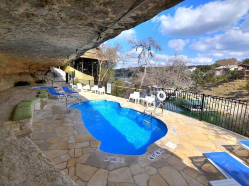 a pool in a cave with blue water in a yard at Treetop Bungalow - Community Pool Hot Tub #18 in Lakeway