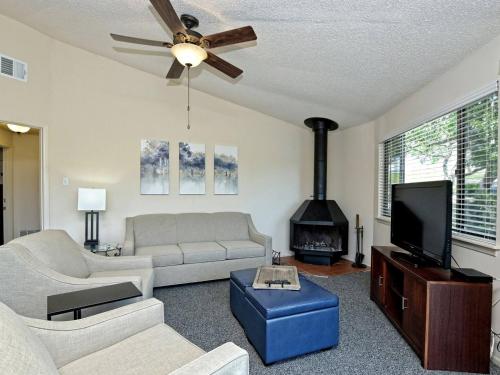a living room with a couch and a fireplace at Treetop Bungalow - Community Pool Hot Tub #18 in Lakeway