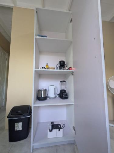 a pantry with white shelves with appliances on them at Sans Oasis in Castries