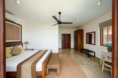 a bedroom with a bed and a ceiling fan at Jetwing Villa 700 in Bentota