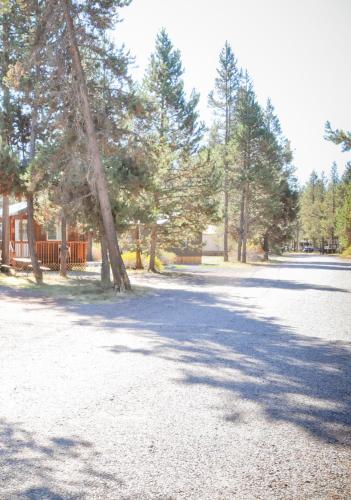 a road with trees and a house in the background at Bend-Sunriver Camping Resort Two-Bedroom Cabin 5 in Sunriver