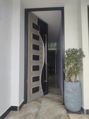 a hallway with a door with a plant in a barrel at Minisuit, Loja in Loja