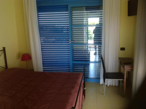 a bedroom with a bed and a sliding glass door at Le Torri in Santa Marinella