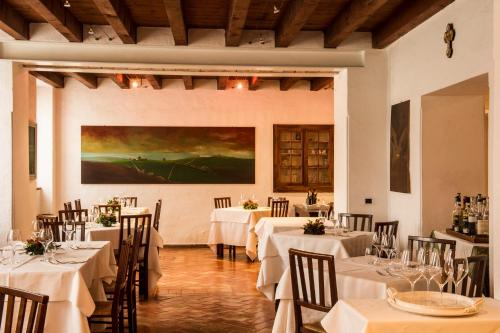 Villa de Winckels في Tregnago: مطعم بطاولات بيضاء وكراسي ولوحة