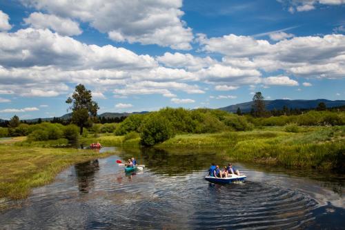 a group of people in boats on a river at Bend-Sunriver Camping Resort 24 ft. Yurt 16 in Sunriver