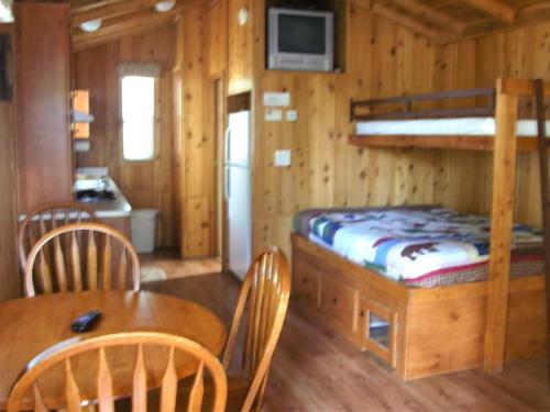 a room with a dining table and a bunk bed at Bend-Sunriver Camping Resort Studio Cabin 6 in Sunriver