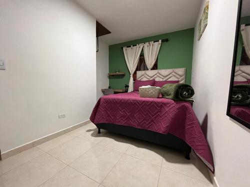 a bedroom with a bed with a purple bedspread at Olivo House in Envigado