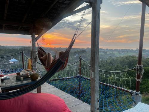 a hammock on a house with a view of the sunset at Dream Hill in Lovina