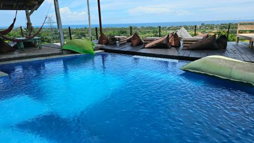 a large blue swimming pool with pillows on a patio at Dream Hill in Lovina