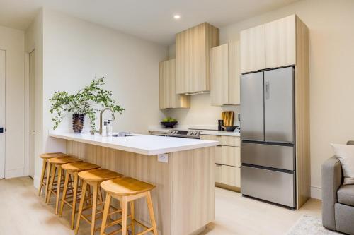 a kitchen with a counter with stools and a refrigerator at Casa De La Vina - Boutique Apartments in Downtown Santa Barbara in Santa Barbara