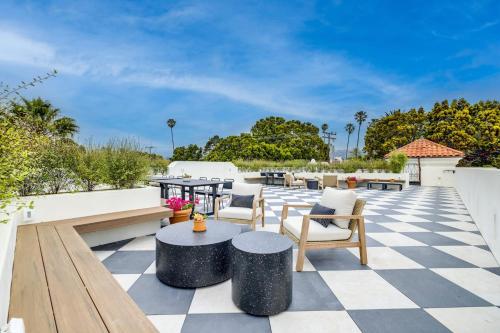 a patio with tables and chairs on a checkered floor at Casa De La Vina - Boutique Apartments in Downtown Santa Barbara in Santa Barbara