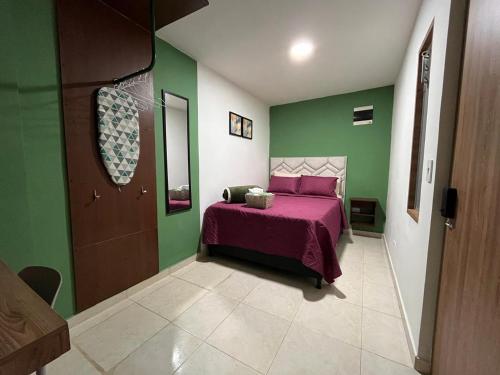 a bedroom with a pink bed and green walls at Olivo House in Envigado