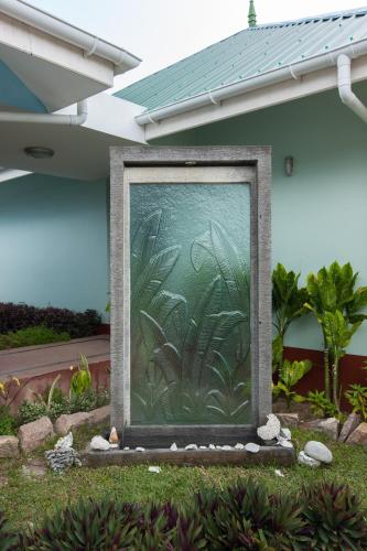 a painting of plants on the side of a house at Le Relax Self Catering Apartment in La Digue