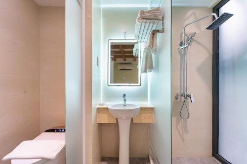 a bathroom with a sink and a shower at Nicecy Hotel - Trương Quyền in Ho Chi Minh City