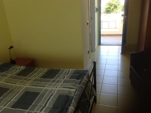 a bedroom with a bed and a door leading to a patio at Le Torri in Santa Marinella