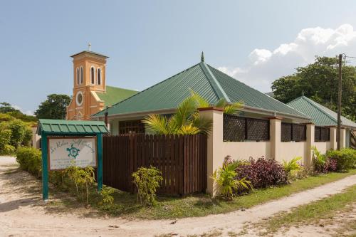 a church with a clock tower in the background at Le Relax Self Catering Apartment in La Digue