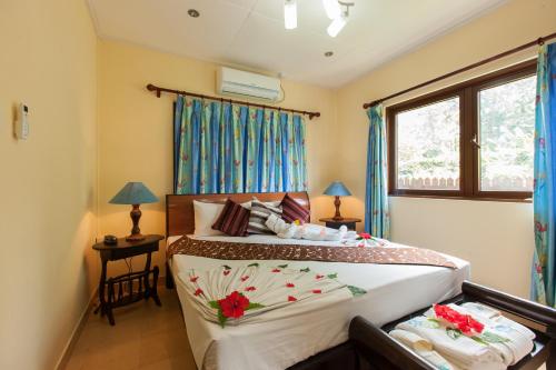 a bedroom with two beds and a window at Le Relax Self Catering Apartment in La Digue