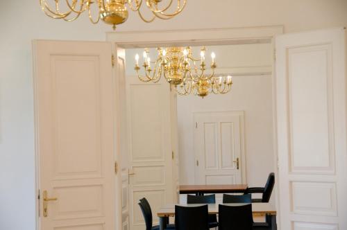 a dining room with a table and chairs and a chandelier at Schloss Gumpoldskirchen in Gumpoldskirchen