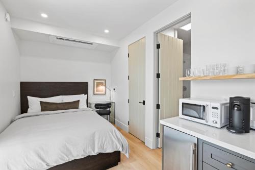 a bedroom with a bed and a microwave on a counter at Casa Jardin - Boutique Suites in Downtown Santa Barbara in Santa Barbara